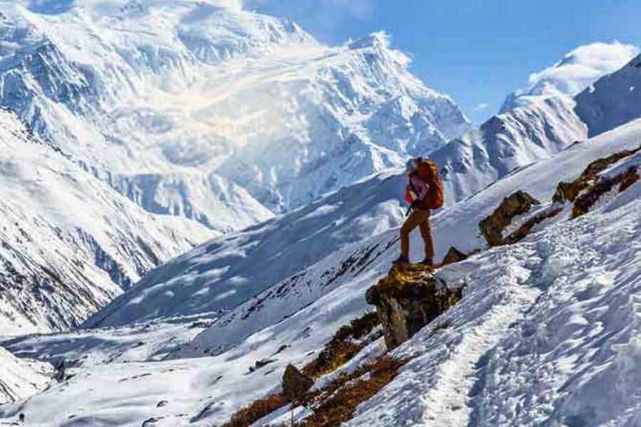 A solo trekker, treks in the Himalayas standing into the leap of the Brahmatal mountain.